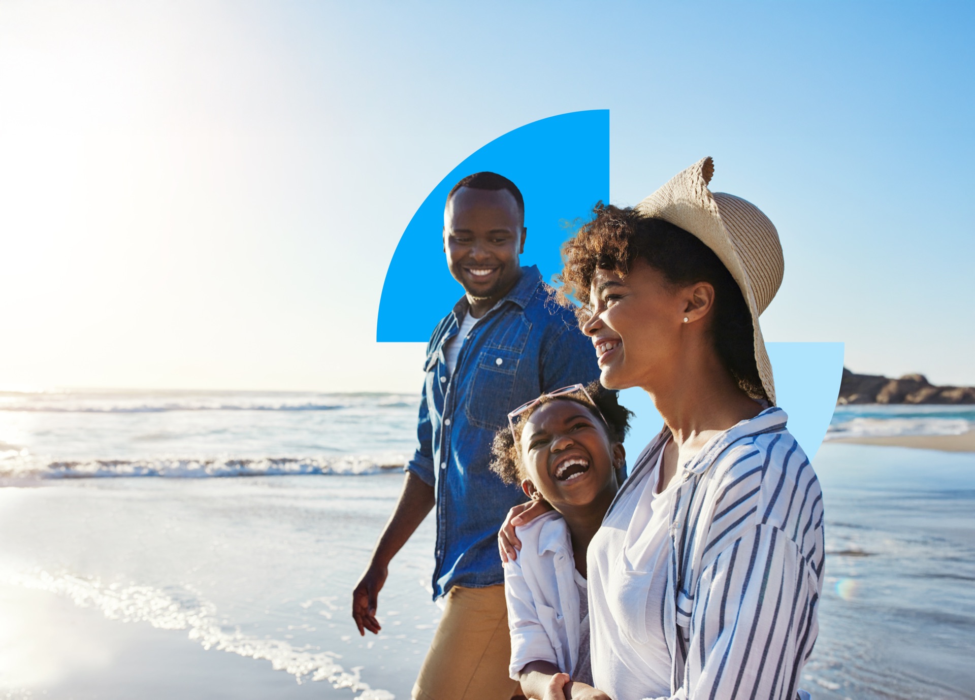 A family smiling together on a sunny beach